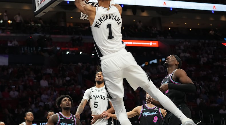 San Antonio Spurs forward Victor Wembanyama (1) dunks over Miami Heat center Bam Adebayo, right, during the first half of an NBA basketball game, Monday, March 23, 2026, in Miami. (AP Photo/Lynne Sladky)