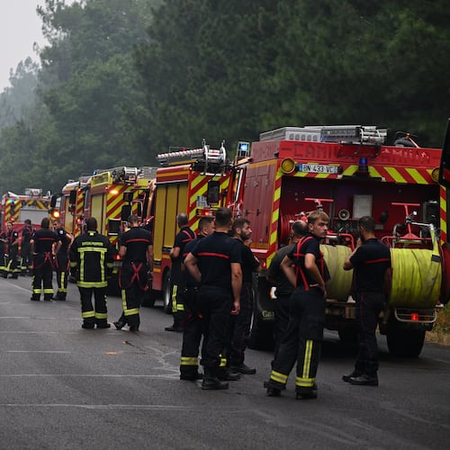 Firefighters wait on a road near Lacanau, southwestern France, Saturday, July 25, 2026. (AP Photo/Emma Da Silva)