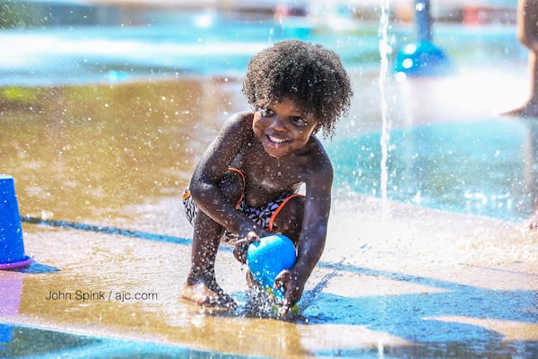 With Monday expected to feel like a 'steam bath,' 2-year-old Tre Toole decided to cool off in the Historic Old Fourth Ward Splash Pad. JOHN SPINK / JSPINK@AJC.COM