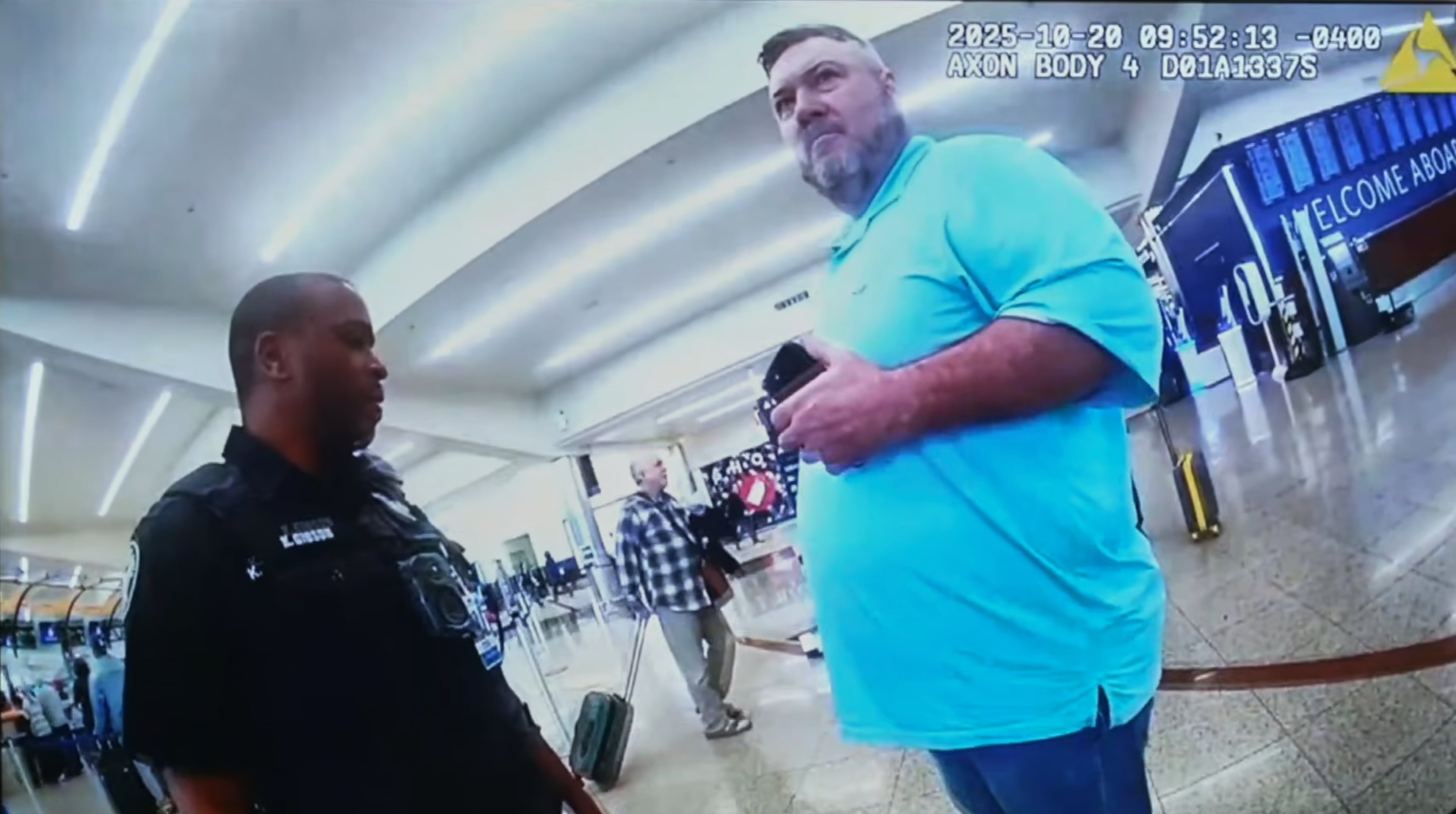 This image made from an Oct. 20, 2025, police body camera footage shows Billy Joe Cagle, of Cartersville, Ga., right, talking to a police officer before he was arrested inside the domestic terminal at Hartsfield-Jackson Atlanta International Airport in Atlanta. (Atlanta Police Department via AP)