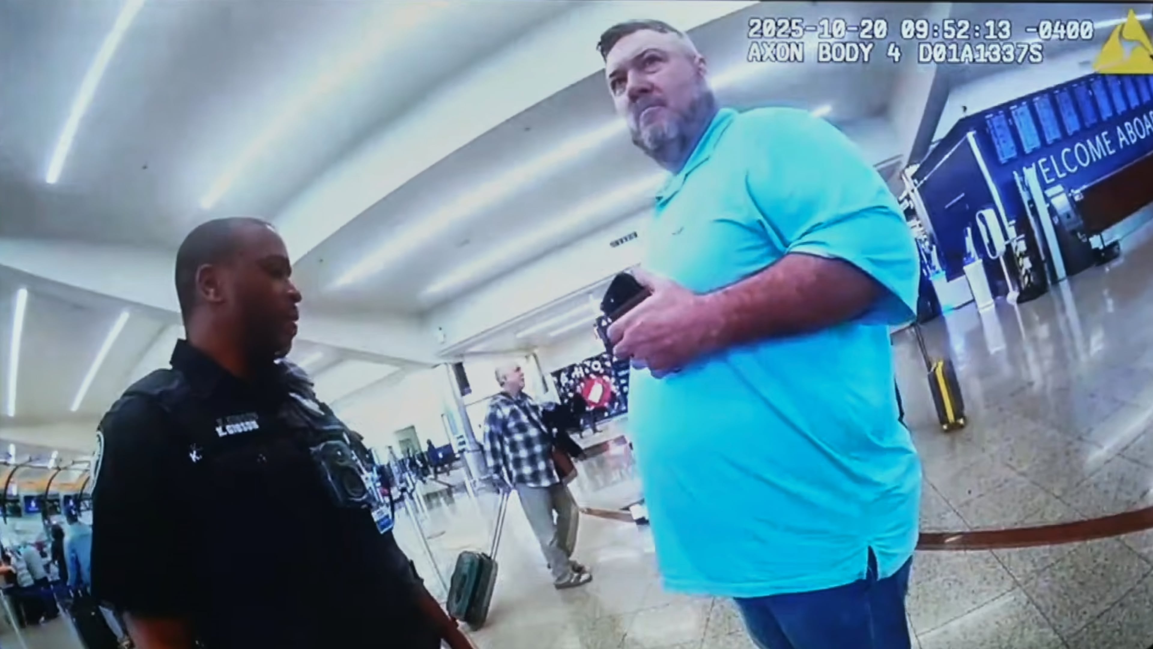 This image made from an Oct. 20, 2025, police body camera footage shows Billy Joe Cagle, of Cartersville, Ga., right, talks to police officers before he was arrested inside the domestic terminal at Hartsfield-Jackson Atlanta International Airport in Atlanta. (Atlanta Police Department via AP)