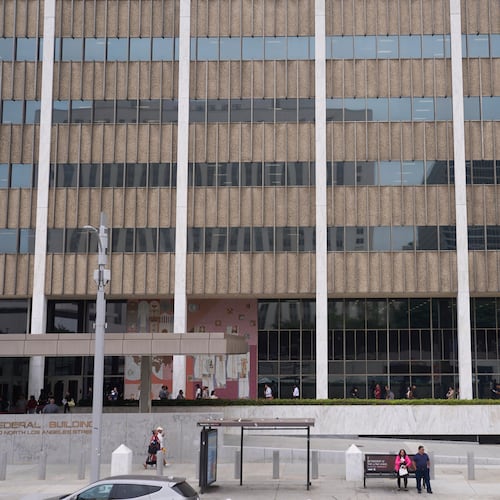 FILE People line up outside the Los Angeles Federal Building in Los Angeles, June 25, 2025. (AP Photo/Damian Dovarganes, File)
