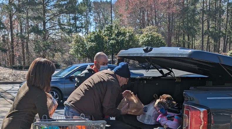 Volunteers load groceries for a client at the Neighborhood Cooperative Ministries in Norcross.