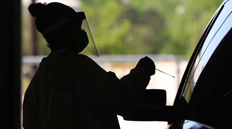 Emory Hospital RN Aisha Bennett takes a nasal swab at a pilot drive-through COVID-19 testing site in the Georgia International Horse Park on Thursday, April 16, 2020, in Conyers. Curtis Compton ccompton@ajc.com