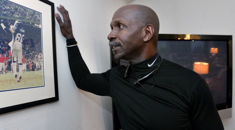 Terry LeCount looks at a photo from his years as an NFL player with the Minnesota Vikings. LeCount struggled with addiction but went on to spend a decade as a paraprofessional at Oakhurst Elementary School in Decatur and now works at the College Football Hall of Fame Museum. HYOSUB SHIN / HSHIN@AJC.COM