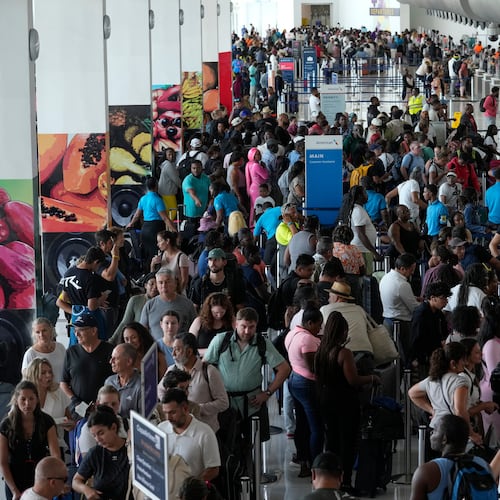 Passengers check in at the Norman Manley International Airport in Kingston, Jamaica, Saturday, Nov. 1, 2025, in the aftermath of Hurricane Melissa. (AP Photo/Matias Delacroix)