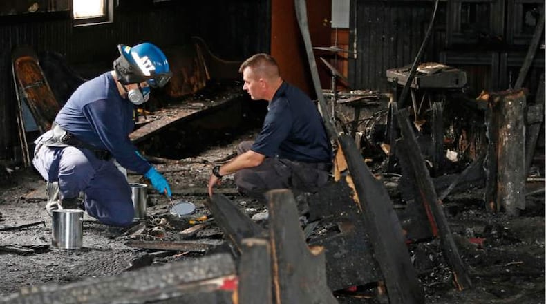 A state fire marshal (right) and an ATF agent collect evidence as they investigate the fire-damaged Hopewell Missionary Baptist Church in Greenville, Miss., Nov. 2. Fire Chief Ruben Brown Sr. said firefighters found flames and smoke pouring from the sanctuary of the church after 9 p.m. Nov. 1. AP PHOTO / ROGELIO V. SOLIS