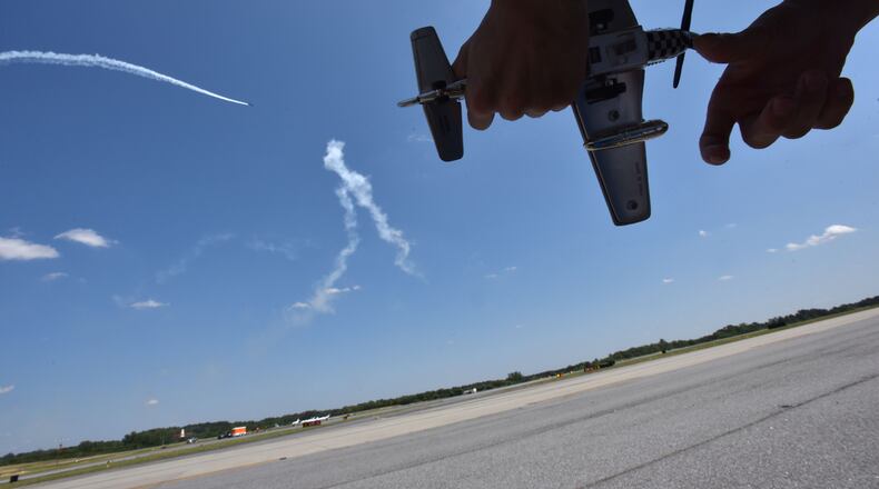A boy holds his toy plane as he watches during the Good Neighbor Day Air Show at the DeKalb Peachtree Airport in 2016. HYOSUB SHIN / HSHIN@AJC.COM