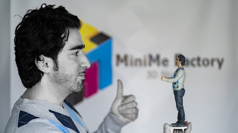 Founder of MiniMe Factory in Alpharetta, Reza Gian Nourali, holds a 9-inch reproduction of himself.