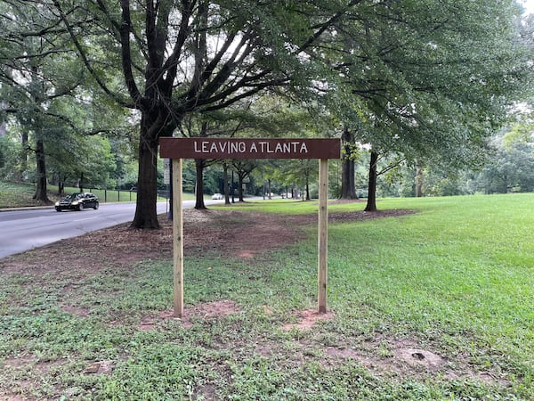 A new, taller version of the “Leaving Atlanta” sign has been erected on Ponce de Leon Avenue in Olmsted Linear Park along the city's edge. (Pete Corson/AJC)