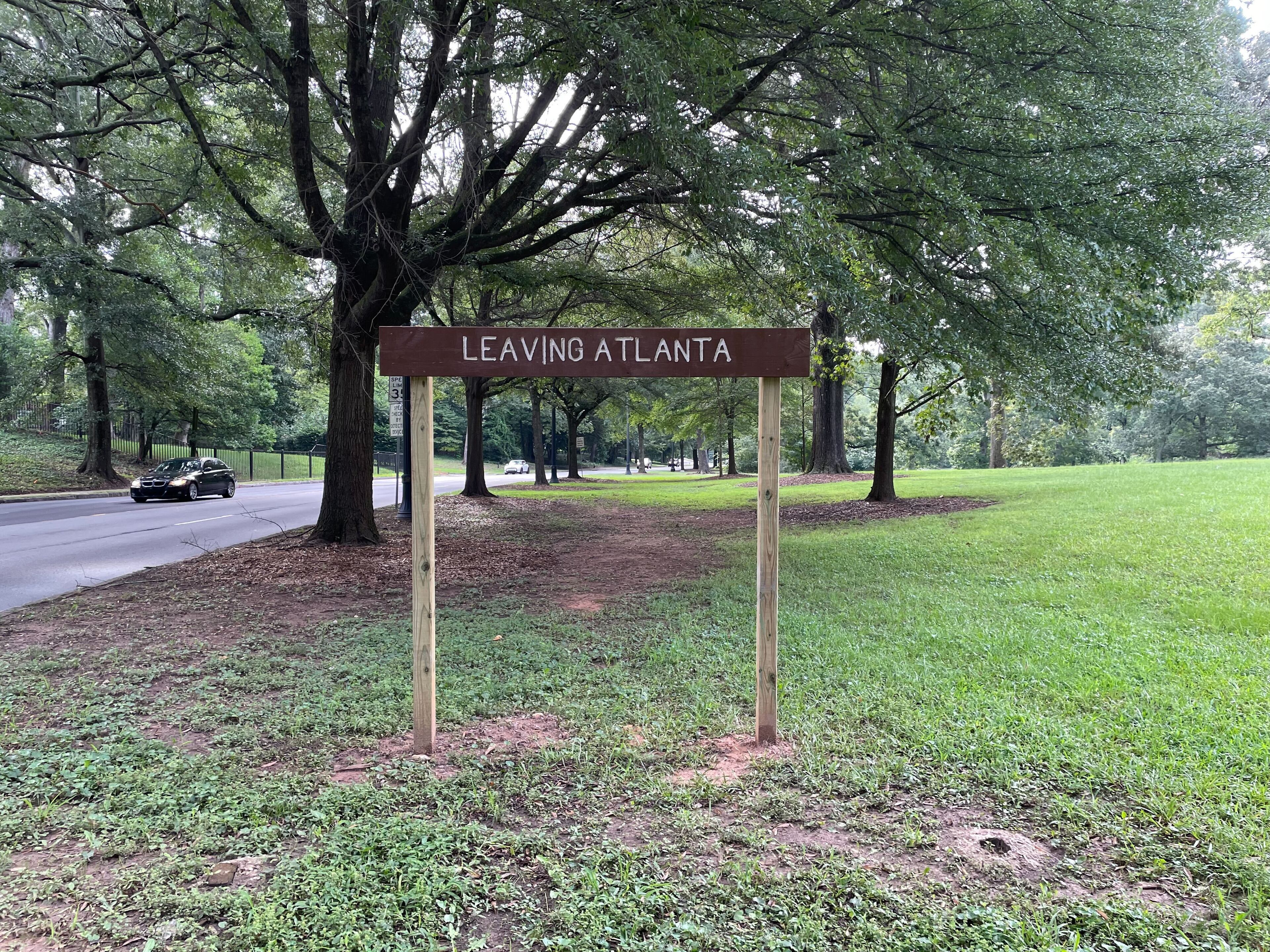 A new, taller version of the “Leaving Atlanta” sign has been erected on Ponce de Leon Avenue in Olmsted Linear Park along the city's edge. (Pete Corson/AJC)