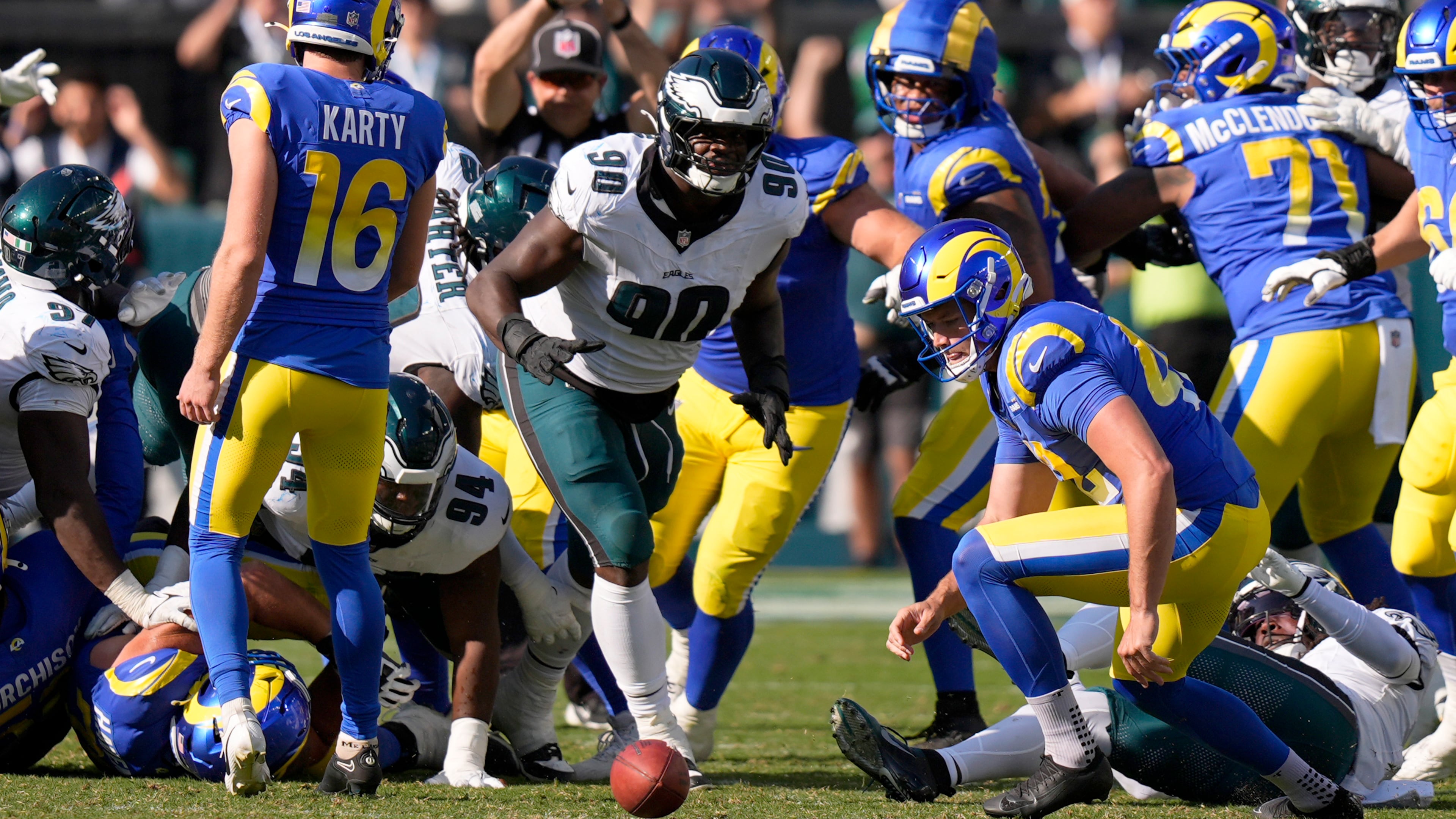 Philadelphia Eagles defensive tackle Jordan Davis (90) prepares to pick up the ball after blocking a field goal attempt by Los Angeles Rams kicker Joshua Karty (16) and run the ball back for a touchdown as time expires during the second half of an NFL football game against the Los Angeles Rams Sunday, Sept. 21, 2025, in Philadelphia. (AP Photo/Chris Szagola)