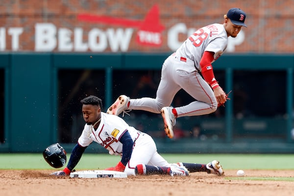 Braves second baseman Ozzie Albies slides into second after being hit by a throw during Sunday's game.
