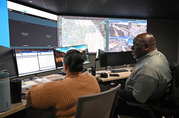 Detective P.D. Harrington (right) confers with analyst Chirley Shealey as they monitor camera feeds from around DeKalb County in January at the Real Time Crime Center in Tucker, which opened in December 2025. (Hyosub Shin/AJC)