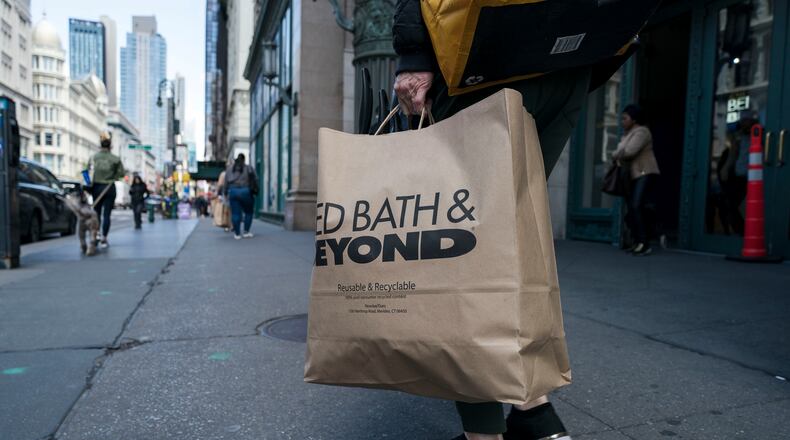 A shopper carries a Bed Bath & Beyond bag outside the company’s store in the Chelsea neighborhood of New York. The retailer filed for bankruptcy this week and is laying off 1,000 workers at its Jackson County distribution center. (Karsten Moran/The New York Times)