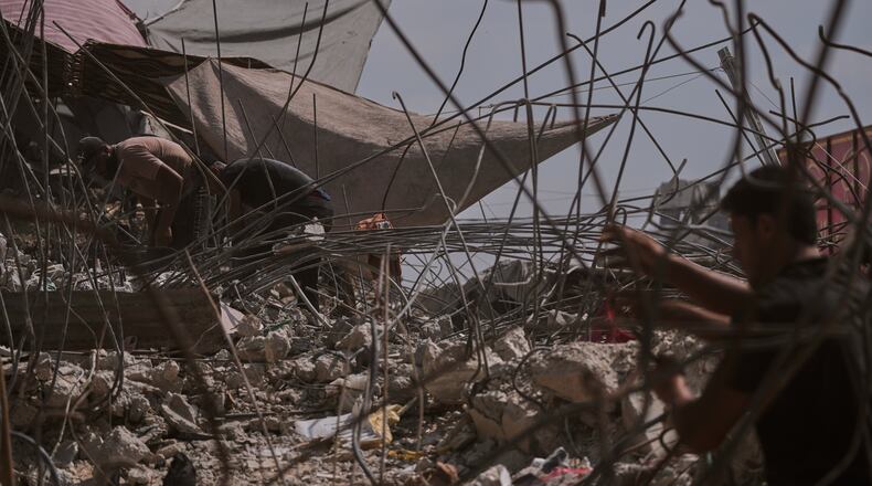 Palestinians remove iron from the rubble of buildings destroyed by Israeli airstrikes during the war with Hamas, repair and recycle it for construction, building tents or selling it, in Gaza City, Sunday, Aug. 16, 2026. (AP Photo/Jehad Alshrafi)