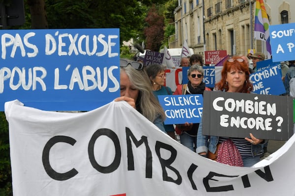 People demonstrate with posters reading "No excuse for abuses", left, and "How many more?", right, ahead of the verdict in the trial of Joel Le Scouarnec, a 74-year-old former surgeon, accused of raping and sexually assaulting 299 children, Wednesday, May 28, 2025 in Vannes, Brittany, western France. (AP Photo/Mathieu Pattier)