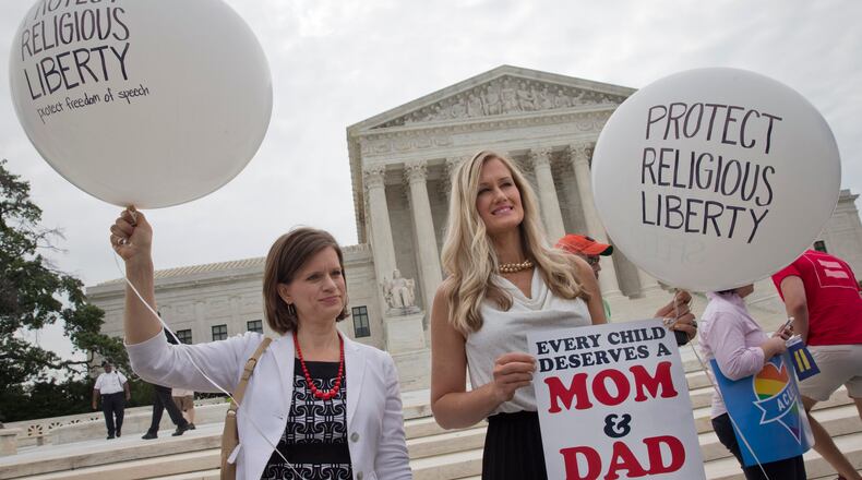 Jennifer Marshall, with the Heritage Foundation, and Summer Ingram, with the Congressional Prayer Caucus Foundation, who said they support “traditional marriage,” hold balloons that say “protect religious liberty” outside of the Supreme Court Friday June 26, 2015, in Washington, before the court declared that same-sex couples have a right to marry anywhere in the U.S. (AP Photo/Jacquelyn Martin)