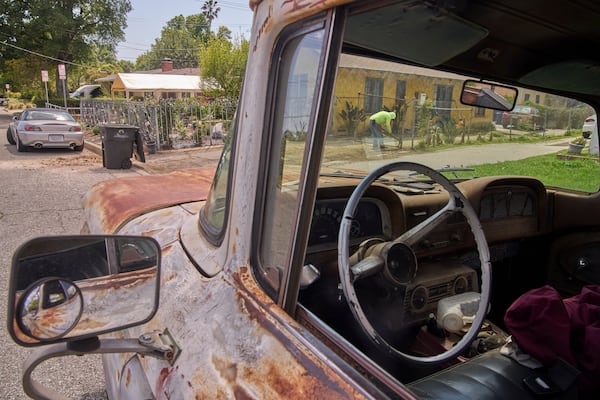An immigrant gardener clears the dirt of the front lawn of a home located within the Eaton Fire damaged area in Altadena, Calif., on Friday, April 4, 2025. (AP Photo/Damian Dovarganes)
