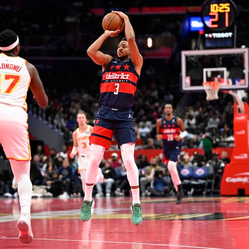 Washington Wizards guard CJ McCollum (3) launches a three point shot in front of Atlanta Hawks forward Onyeka Okongwu (17) during the first half of a Emirates NBA Cup basketball game Tuesday, Nov. 25, 2025, in Washington. (AP Photo/John McDonnell)