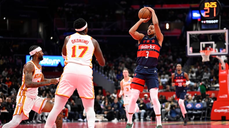Washington Wizards guard CJ McCollum (3) launches a three point shot in front of Atlanta Hawks forward Onyeka Okongwu (17) during the first half of a Emirates NBA Cup basketball game Tuesday, Nov. 25, 2025, in Washington. (AP Photo/John McDonnell)
