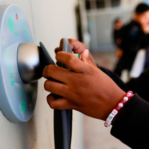 FILE - A middle school student unlocks a Yondr pouch on an unlocking base at Bayside Academy while others wait in line for their turn to unlock their pouch at the end of the school day Aug. 16, 2024, in San Mateo, Calif. (Lea Suzuki/San Francisco Chronicle via AP, File)