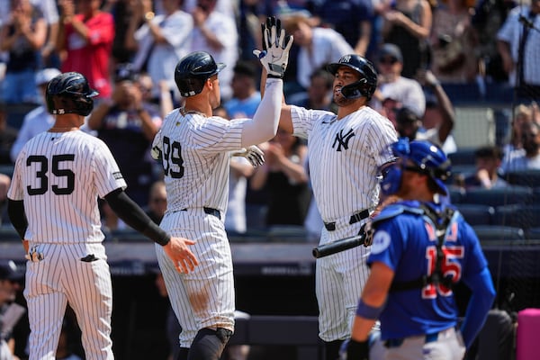 New York Yankees' Aaron Judge (99) celebrates with designated hitter Giancarlo Stanton (27) after hitting a two run home run during the ninth inning of a baseball game against the Chicago Cubs, Saturday, July 12, 2025, in New York. (AP Photo/Yuki Iwamura)