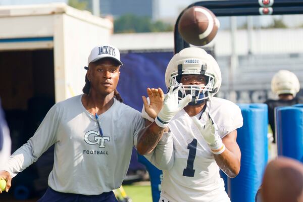 Georgia Tech running back Trelain Maddox works with a notable new assistant receivers coach on Tuesday. (Miguel Martinez/AJC)