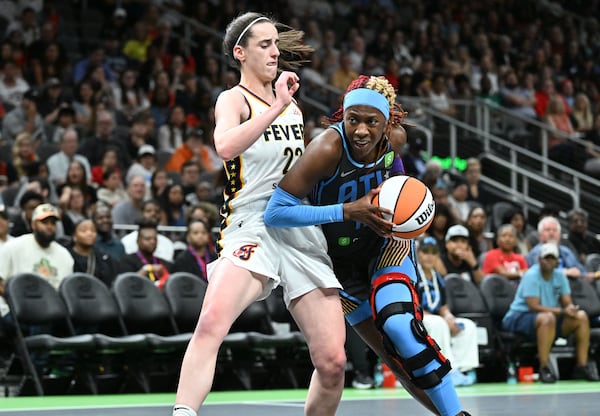 Atlanta Dream guard Rhyne Howard drives against Indiana Fever guard Caitlin Clark during Thursday's game. Beyond her stat line, Howard’s energy fueled her team, from the dustup with Clark at center court to her defensive efforts. (Hyosub Shin/AJC)