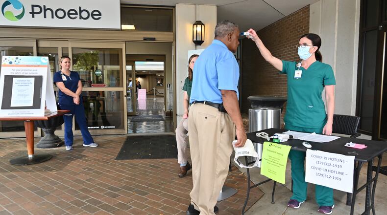 A nurse checks a temperature of an employee before he enters the Phoebe Putney Memorial Hospital in Albany on Tuesday, March 24, 2020. Well off the interstate some 180 miles south-southwest of Atlanta, Albany's struggles with the coronavirus stick out like a sore thumb on the state's map. (Hyosub Shin / Hyosub.Shin@ajc.com)