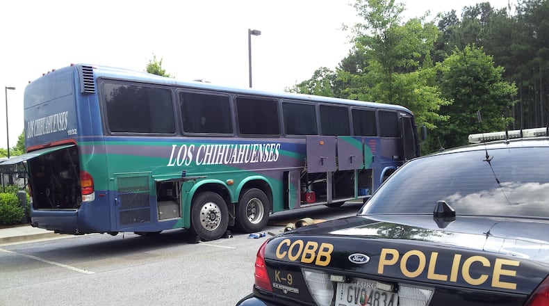 Federal authorities seized this passenger bus Thursday in Cobb County as part of an investigation into an alleged Mexico-to-Atlanta drug smuggling ring. A search of the bus revealed more than 20 kilograms of cocaine, heroin and methamphetamine in a secret compartment. Seventeen Mexican citizens have been indicted as part of the alleged alleged conspiracy, a dozen of whom have either been arrested or located in the metro area. CHRIS JOYNER/AJC