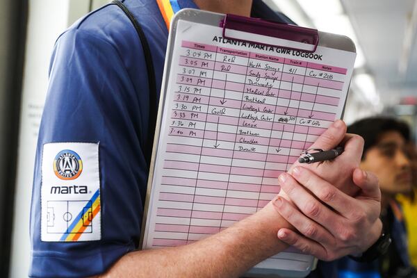 Matthew Plese keeps time in a logbook while attempting to set a Guinness World Record for the fastest time visiting every MARTA station in Atlanta on Thursday, Jan. 8, 2026. (Abbey Cutrer/AJC)