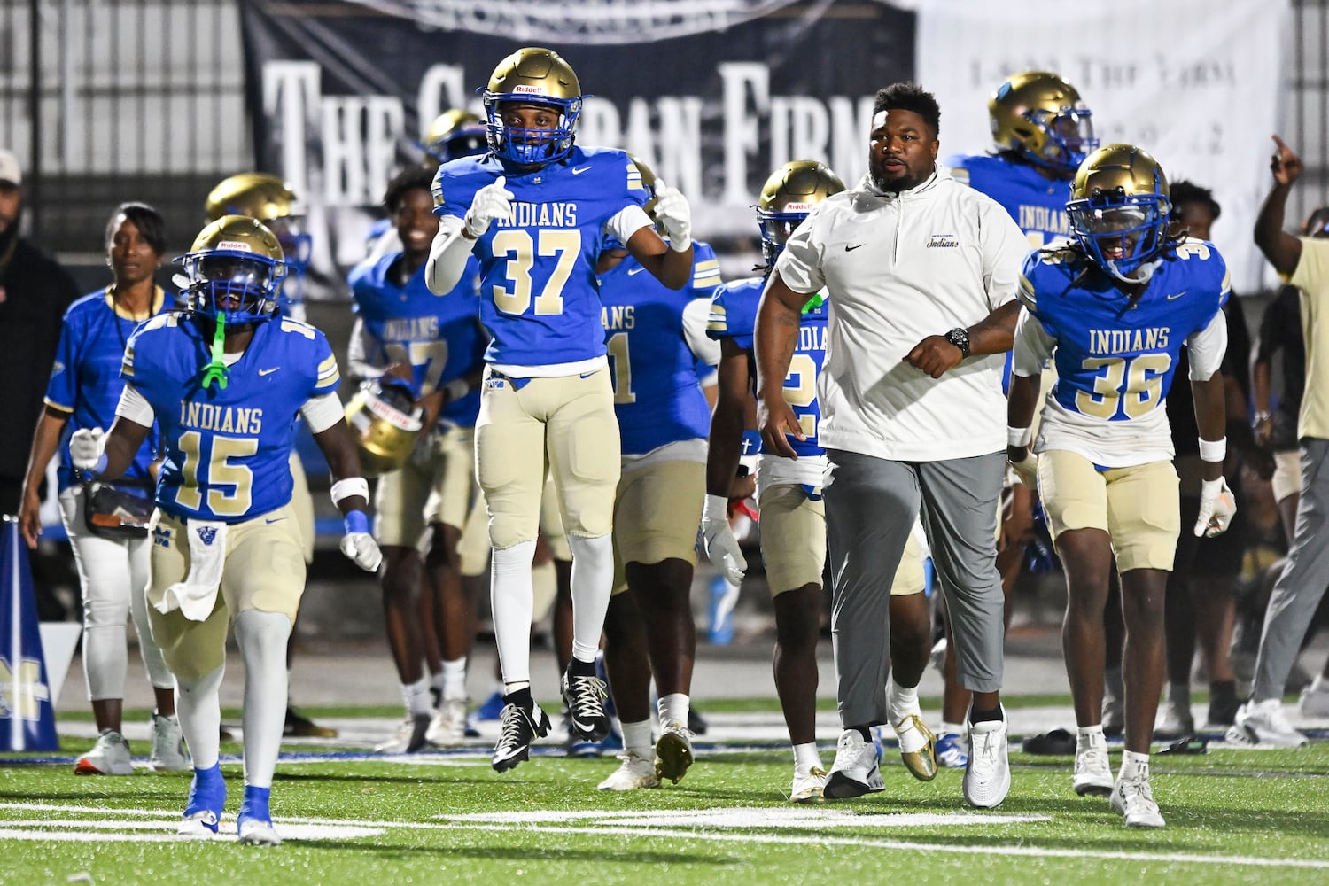 The McEachern Indians celebrate their 21-0 win over North Cobb as time runs out in the second half of play Friday, August 22, 2025 at McEachern.  (Daniel Varnado/For the Atlanta Journal-Constitution)