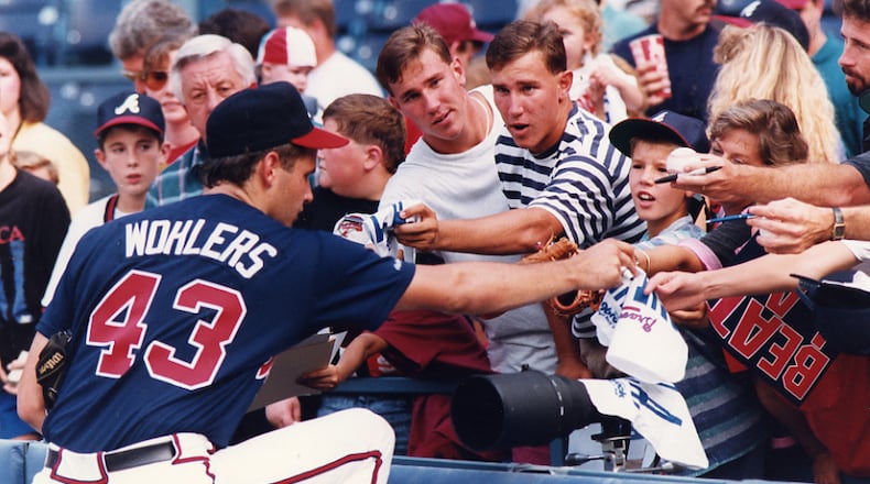 Braves pitcher Mark Wohlers, who was a member of the Altanta trio that combined to no-hit the San Diego Padres two days prior signs autographs for fans before a game. Sept. 13, 1991, in Atlanta.