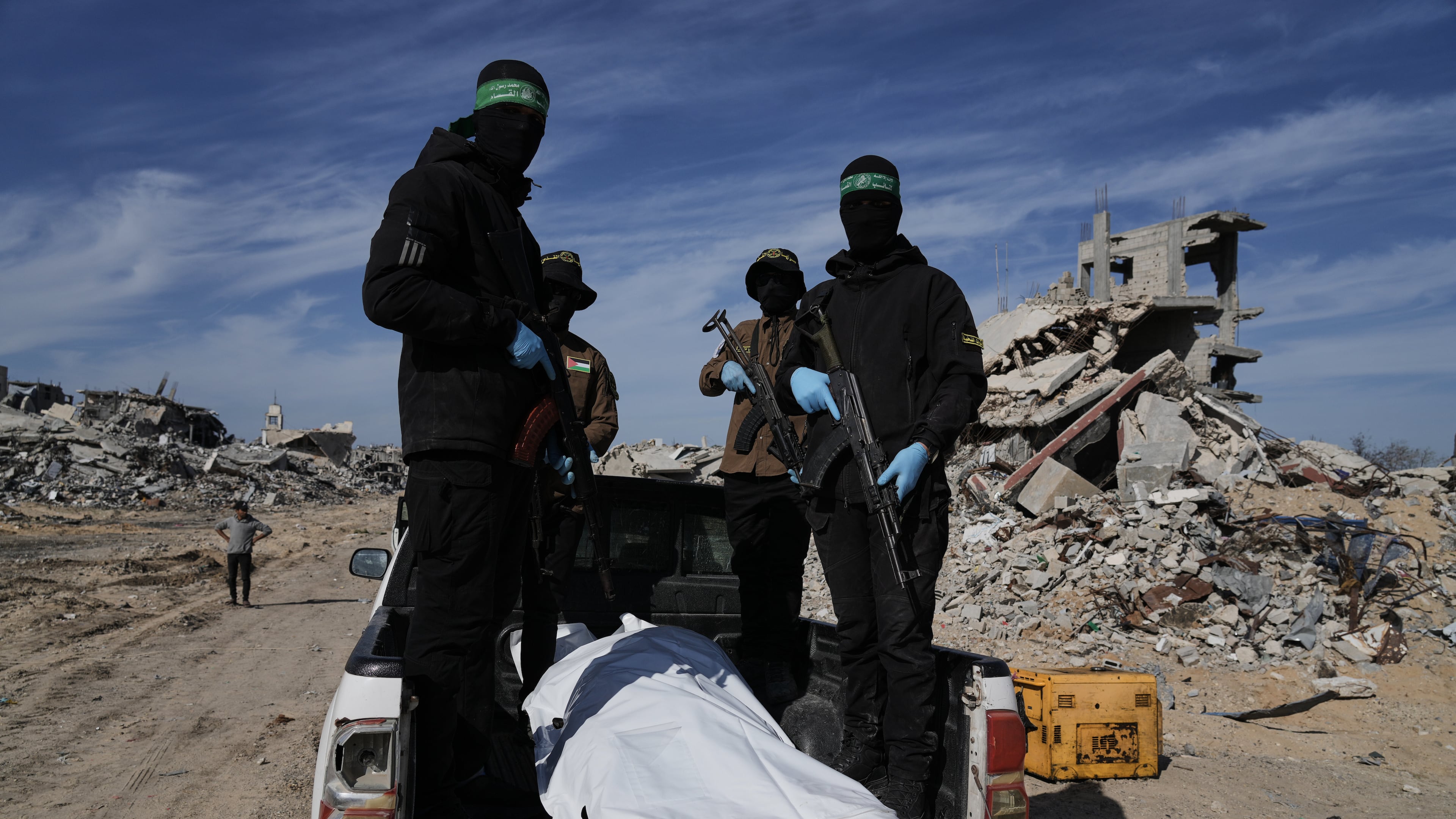 Islamic Jihad and Hamas militants carry a white body bag that is believed to be the remains of a deceased hostage, in the town of Beit Lahiya in northern Gaza Strip, Wednesday, Dec. 3, 2025. (AP Photo/Jehad Alshrafi).