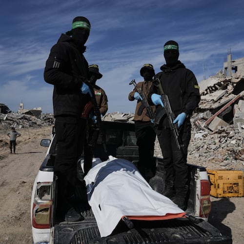 Islamic Jihad and Hamas militants carry a white body bag that is believed to be the remains of a deceased hostage, in the town of Beit Lahiya in northern Gaza Strip, Wednesday, Dec. 3, 2025. (AP Photo/Jehad Alshrafi).