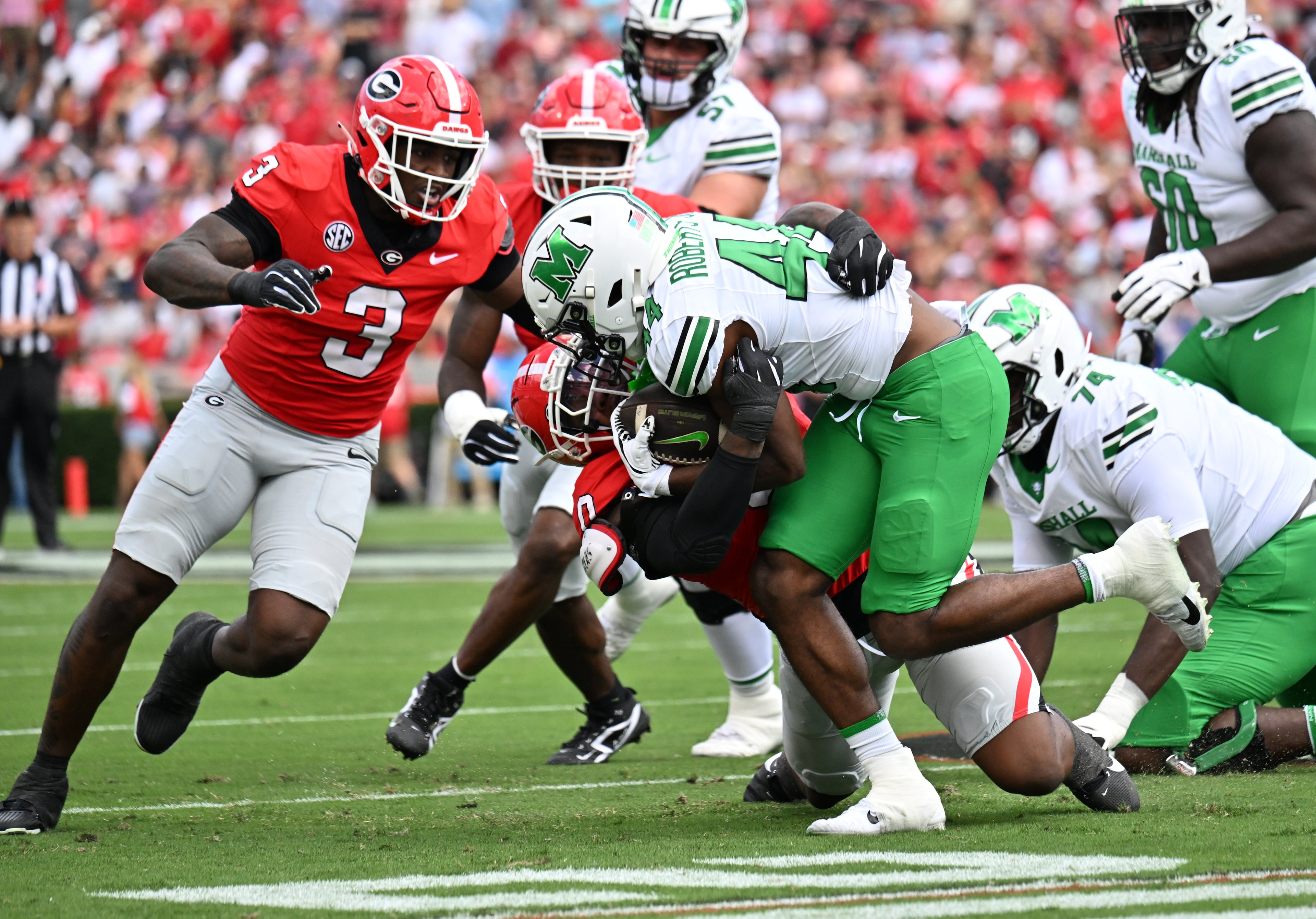 Marshall running back Antwan Roberts (44) is stopped by Georgia linebacker Gabe Harris Jr. (0) during the first half in an NCAA football game at Sanford Stadium, Saturday, August 30, 2025, in Athens. (Hyosub Shin / AJC)