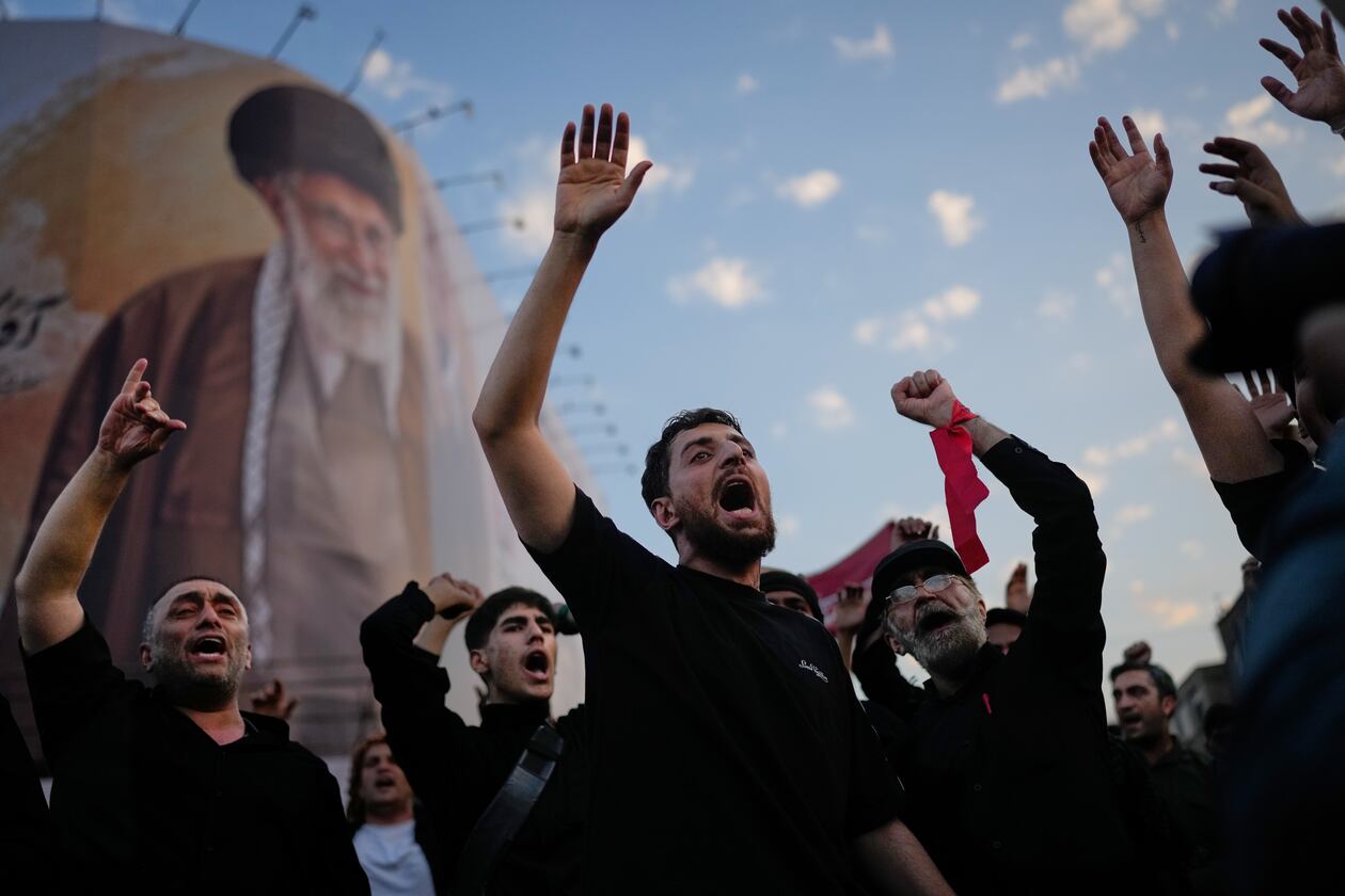 Mourners chant slogans while gathered in Islamic Revolution Square for the funeral procession of the slain Iranian Supreme Leader Ayatollah Ali Khamenei beneath a billboard depicting Khamenei in Tehran, Iran, Monday, July 6, 2026. (AP Photo/Altaf Qadri)