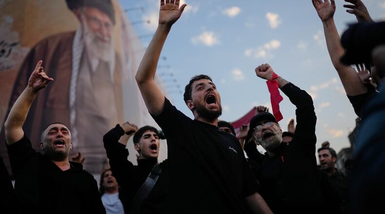 Mourners chant slogans while gathered in Islamic Revolution Square for the funeral procession of the slain Iranian Supreme Leader Ayatollah Ali Khamenei beneath a billboard depicting Khamenei in Tehran, Iran, Monday, July 6, 2026. (AP Photo/Altaf Qadri)