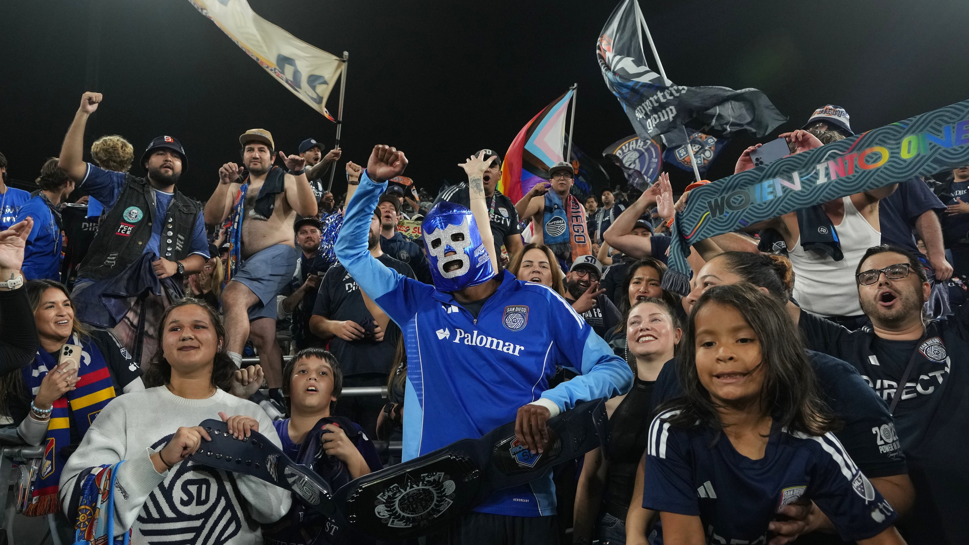 San Diego FC forward Amahl Pellegrino, center, wears a Mexican wrestling mask as he celebrates with fans after San Diego FC defeated the Portland Timbers 4-0 in Game 3 in the first round of MLS soccer's Western Conference playoffs Sunday, Nov. 9, 2025, in San Diego. (AP Photo/Gregory Bull)