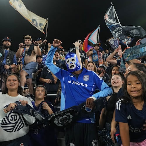 San Diego FC forward Amahl Pellegrino, center, wears a Mexican wrestling mask as he celebrates with fans after San Diego FC defeated the Portland Timbers 4-0 in Game 3 in the first round of MLS soccer's Western Conference playoffs Sunday, Nov. 9, 2025, in San Diego. (AP Photo/Gregory Bull)