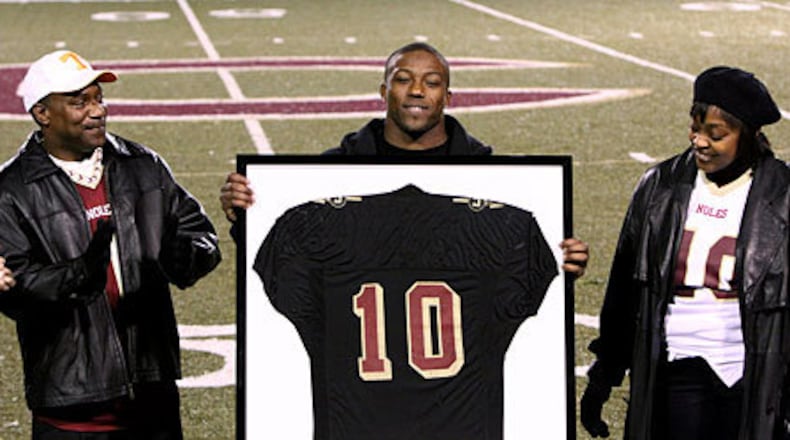 Former Creekside star quarterback Eric Berry, with proud parents James and Carol, accepts his jersey -- the first to be retired by the Seminoles in over 20 years.