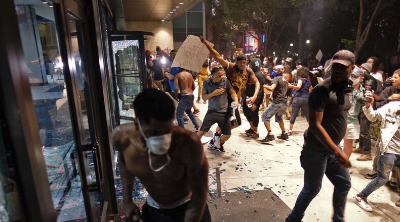 May 29, 2020 - Atlanta - After a peaceful march the Georgia State Capitol that swelled into the hundreds, protestors returned to the area around the Centennial Olympic Park and CNN center where some confronted police, who sprayed some demonstrators with pepper spray. They carried signs and chanted their messages of outrage over the death of George Floyd in Minneapolis. Ben Gray for the Atlanta Journal Constitution