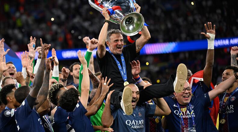 PSG's head coach Luis Enrique, top, celebrates with players after winning the Champions League final soccer match against Arsenal in Budapest, Hungary, Saturday, May 30, 2026. (AP Photo/Denes Erdos)