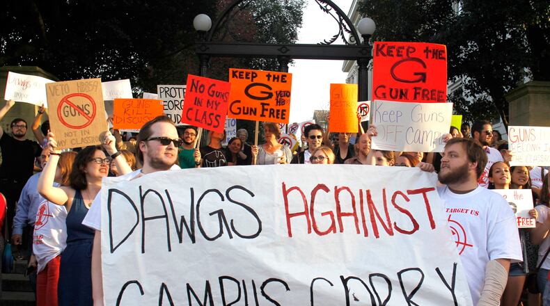 Protesters against campus carry finish their march at the University of Georgia arch. Demonstrators urged Gov. Nathan Deal to veto this year’s campus carry bill, which would allow guns on parts of campus. Deal did veto the bill, but new campus gun legislation may be coming. TAYLOR CARPENTER / TAYLOR.CARPENTER@AJC.COM