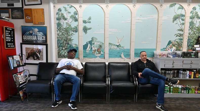 Sulaiman Smith (left), shoeshiner, and Gustavo Espinal, barber, chat as they wait for a customer at Tommy’s Barbershop in Atlanta on Saturday, March 21, 2020. Nationally, a tidal wave of job cuts has followed the closure of restaurants and offices, the cancellation of sports events and conferences and the slashing of travel. Filings for unemployment insurance in Georgia were up at least 400% last week, according to the state Department of Labor. The numbers were even more grim in some other states. (Hyosub Shin / Hyosub.Shin@ajc.com)