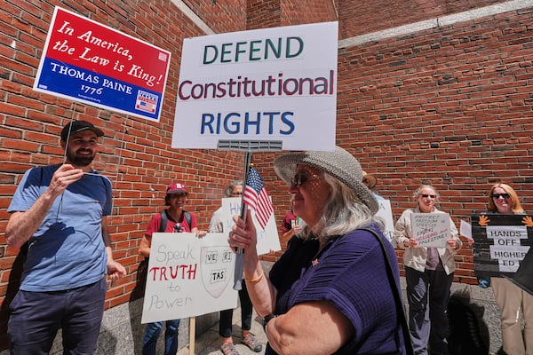 Protestors gather outside the Moakley Federal Courthouse, where Harvard University appeared to challenge $2.6 billion in funding cuts by the Trump administration, Monday, July 21, 2025, in Boston. (AP Photo/Charles Krupa)