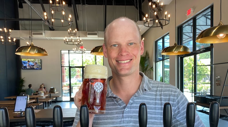 CEO Craig Mycoskie hoists a beer at Round Trip Brewing's Marietta taproom. (Bob Townsend for The Atlanta Journal-Constitution)