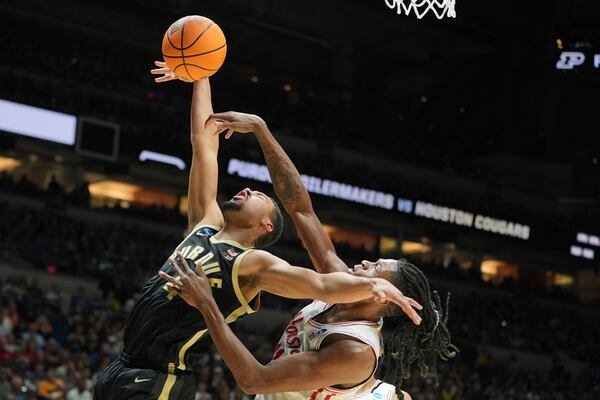 Houston's Joseph Tugler, right, knocks the ball away from Purdue's Trey Kaufman-Renn during the second half in the Sweet 16 of the NCAA college basketball tournament Friday, March 28, 2025, in Indianapolis. (AP Photo/Michael Conroy)