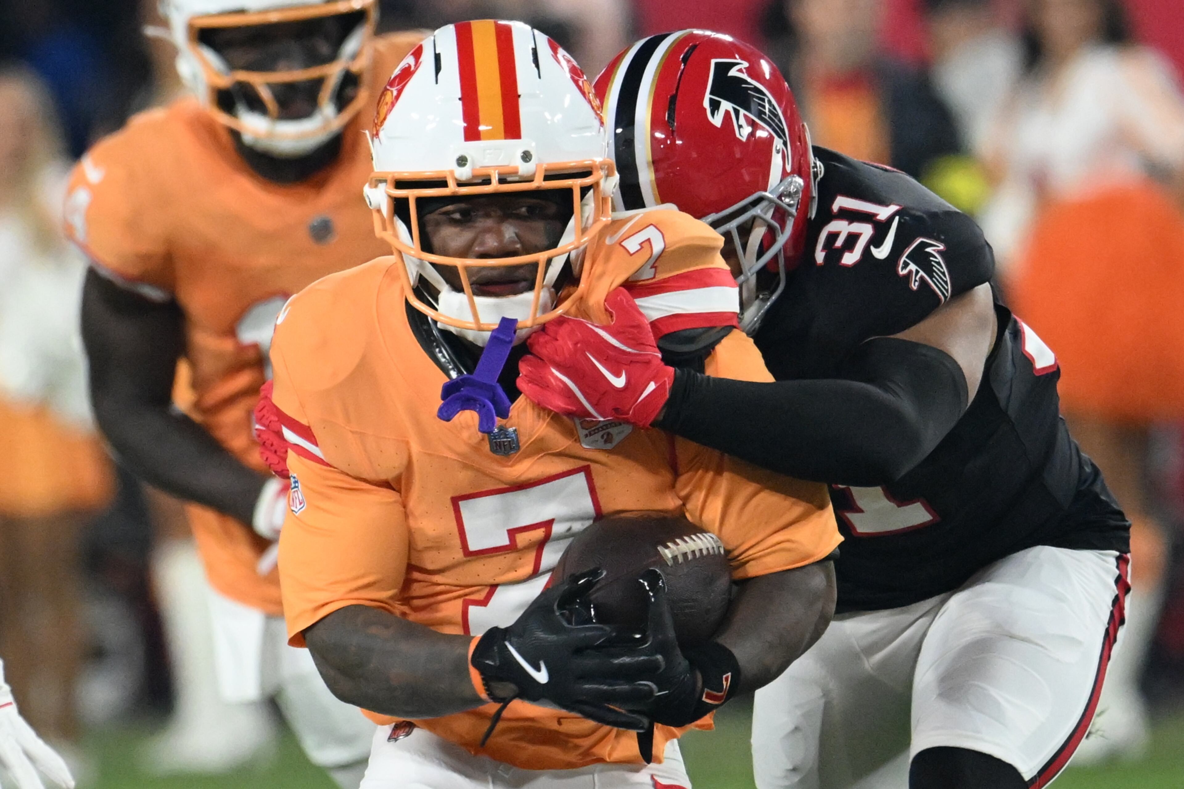 Tampa Bay Buccaneers running back Bucky Irving (7) runs against Atlanta Falcons safety Xavier Watts (31) during the first half of an NFL football game, Thursday, Dec. 11, 2025, in Tampa, Fla. (AP Photo/Jason Behnken)